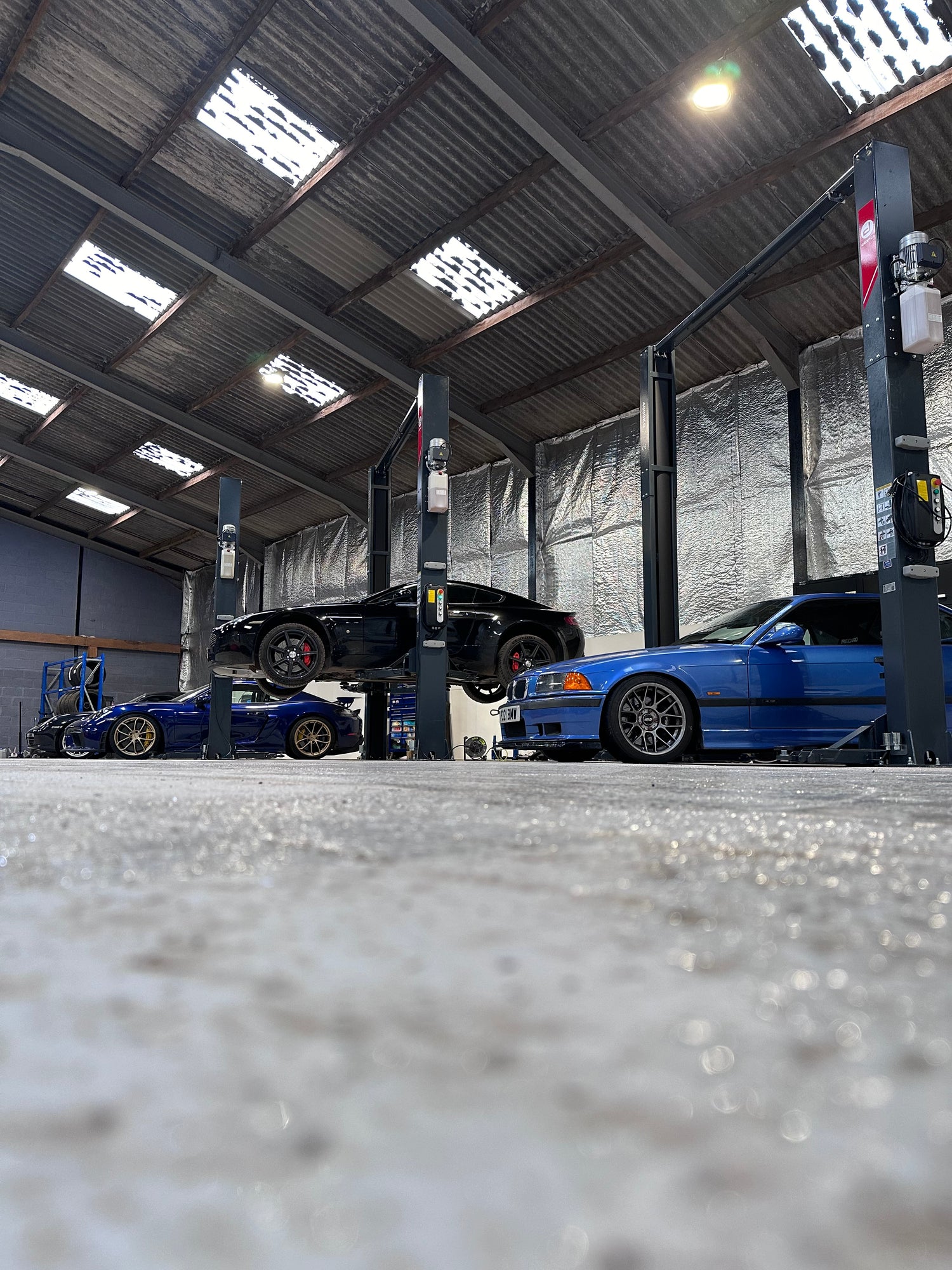 Aston Martin, BMW and Porsche on 2 post ramp